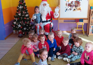 Dzieci pozują z Mikołajem do zdjęcia